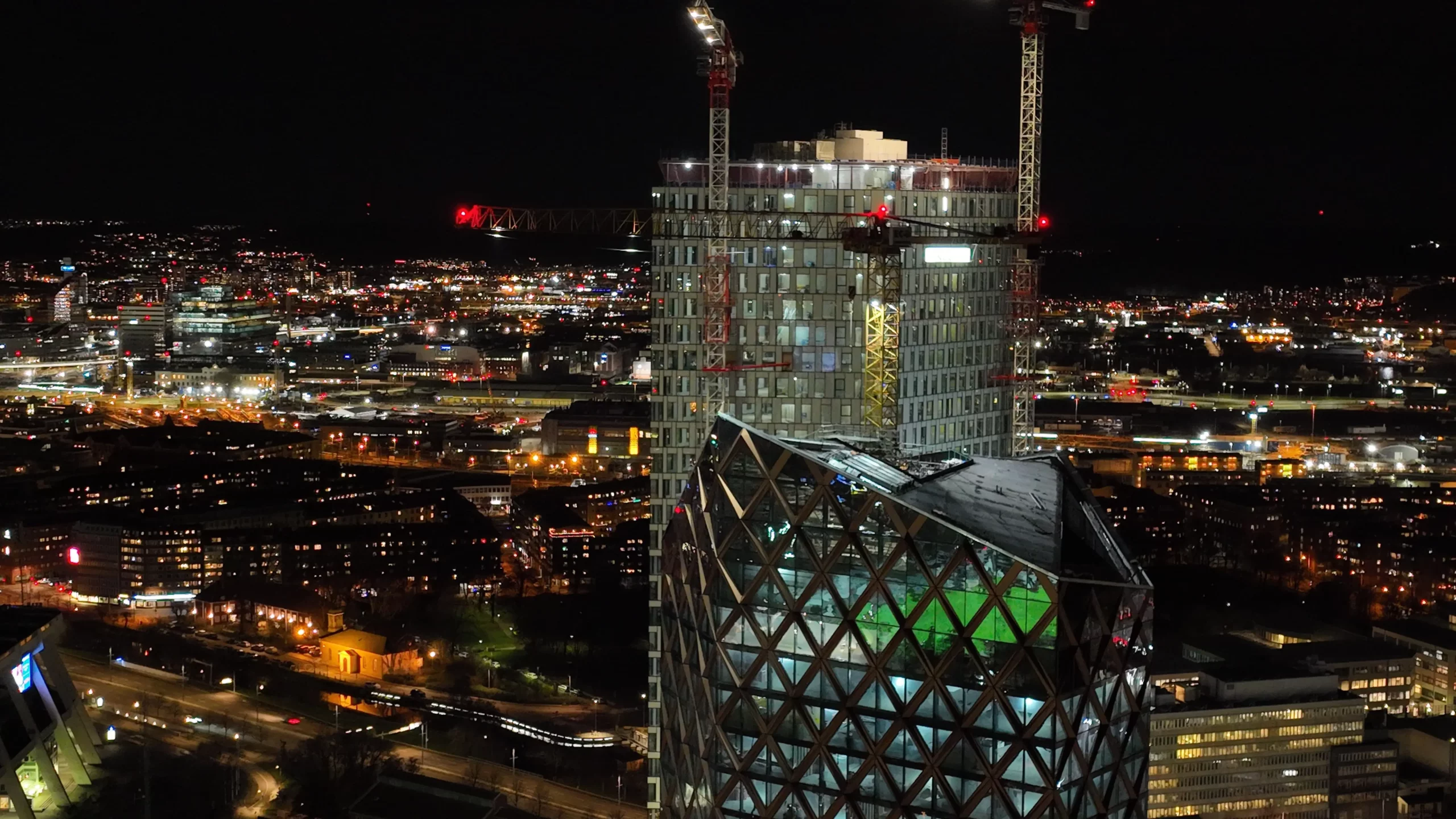 Drönarfoto över upplyst stadsbebyggelse och fastigheter
